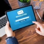 a man holding a tablet subscribing to a newsletter